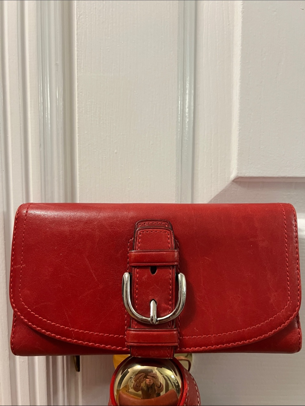 This is a vintage red leather Coach Y2K Soho long buckle wallet featuring silver